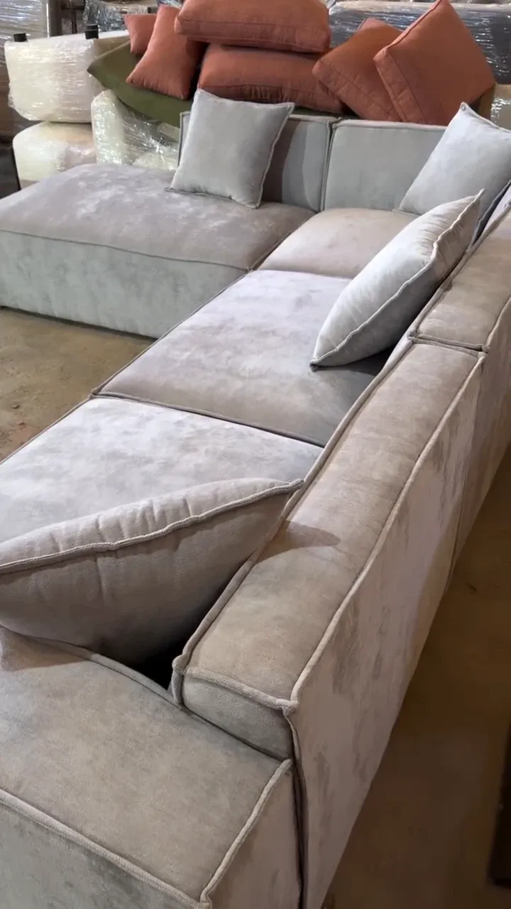 BADAL modular L-shape sofa seen along its long side, showing the separate seat sections and piped edges
