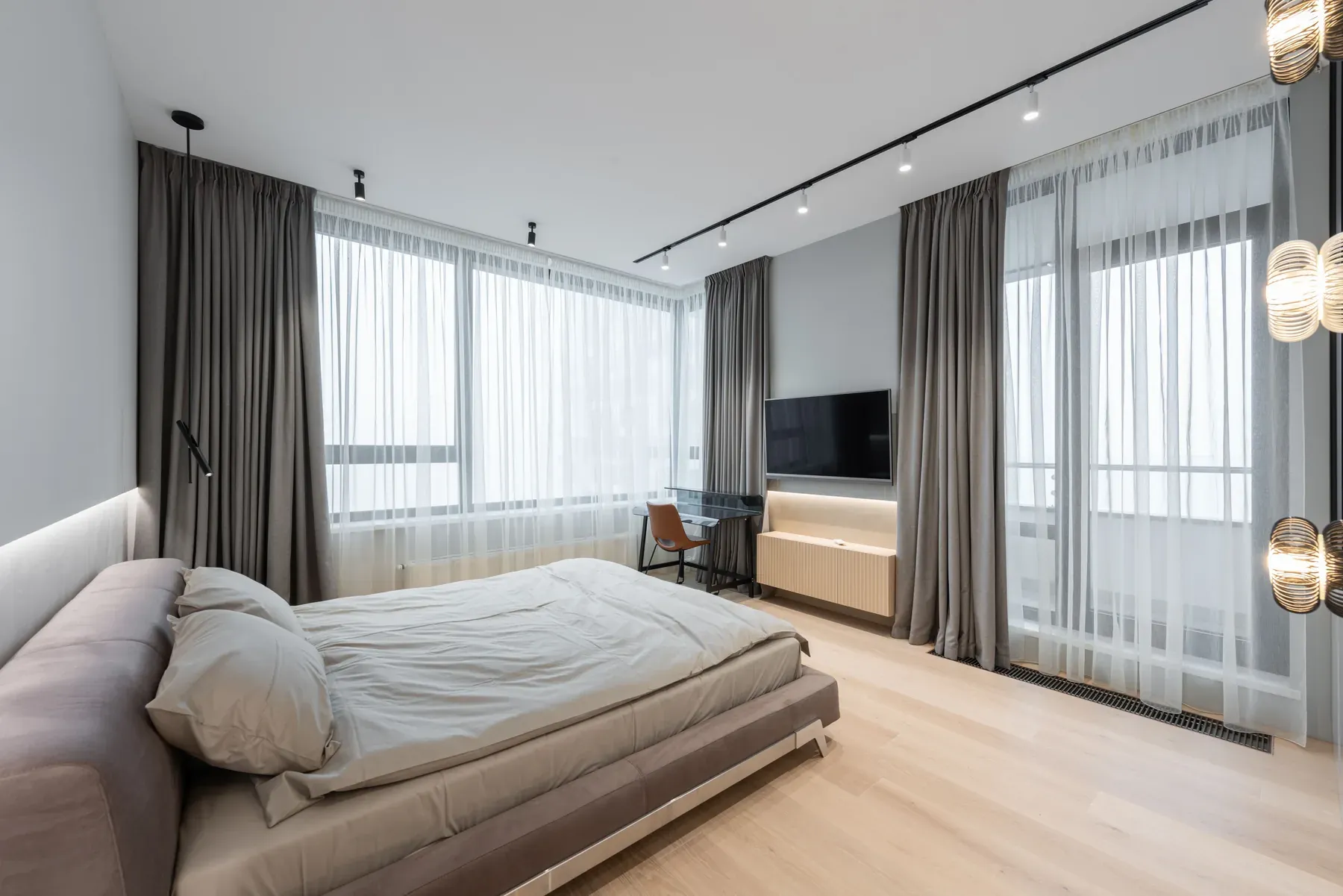 Soft grey upholstered bed in a spacious bedroom — reference image for the NEEND soft-edge upholstered bed