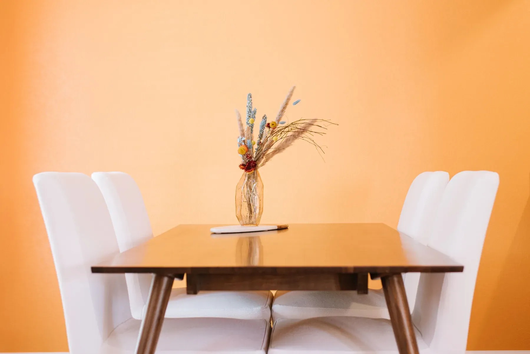 Light wood dining table with four white chairs — reference image for the LAZZAT six-seat dining set