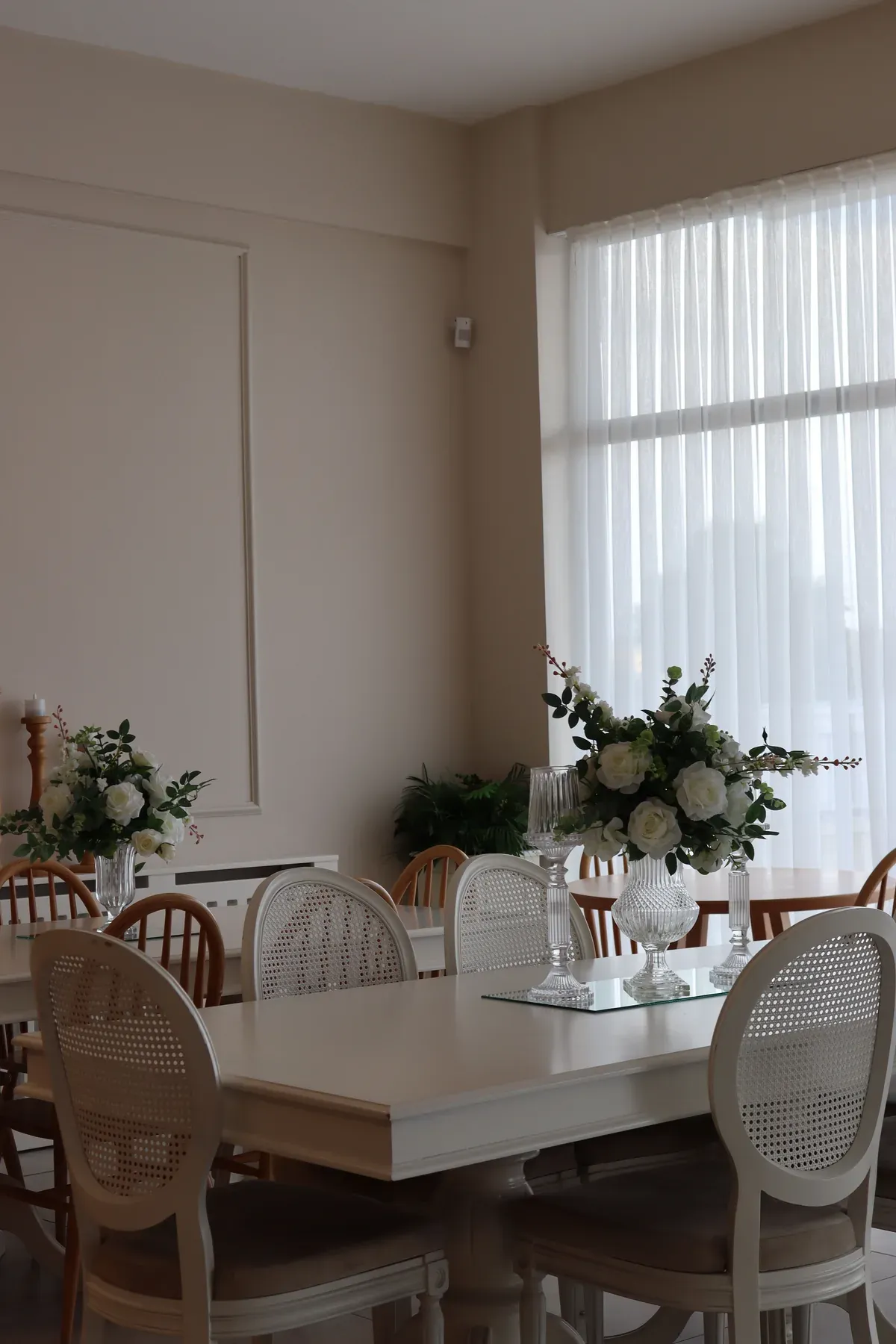 White cane dining chairs around a bright table setting — reference image for the SUFRA cane-back dining set