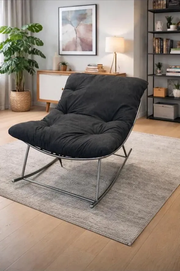 Rocking chair with a metal frame and a dark tufted cushion in a living room — reference image for the JHOOLA rocking chair