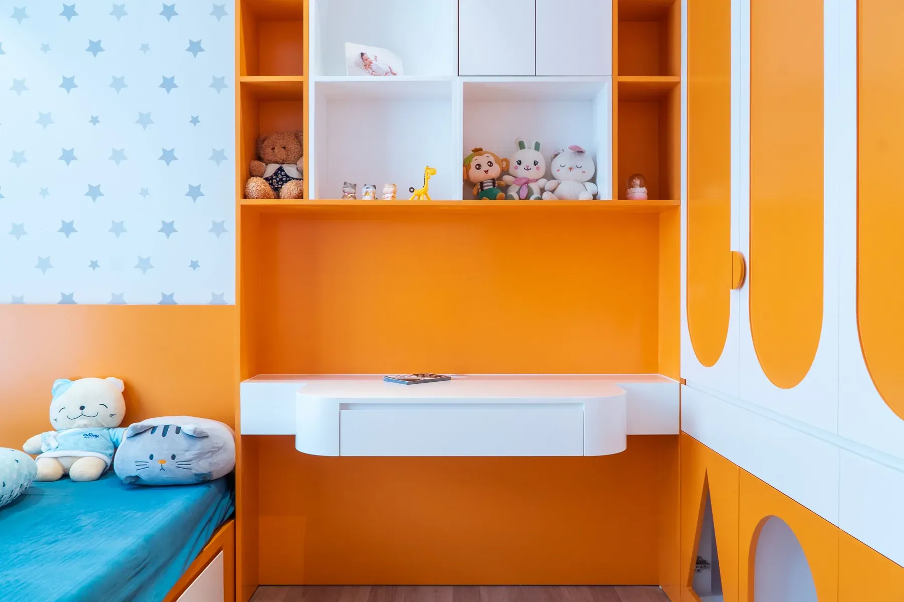 Custom orange kids room with bed, cabinets and desk — reference image for the KHILONA fitted play & study wall