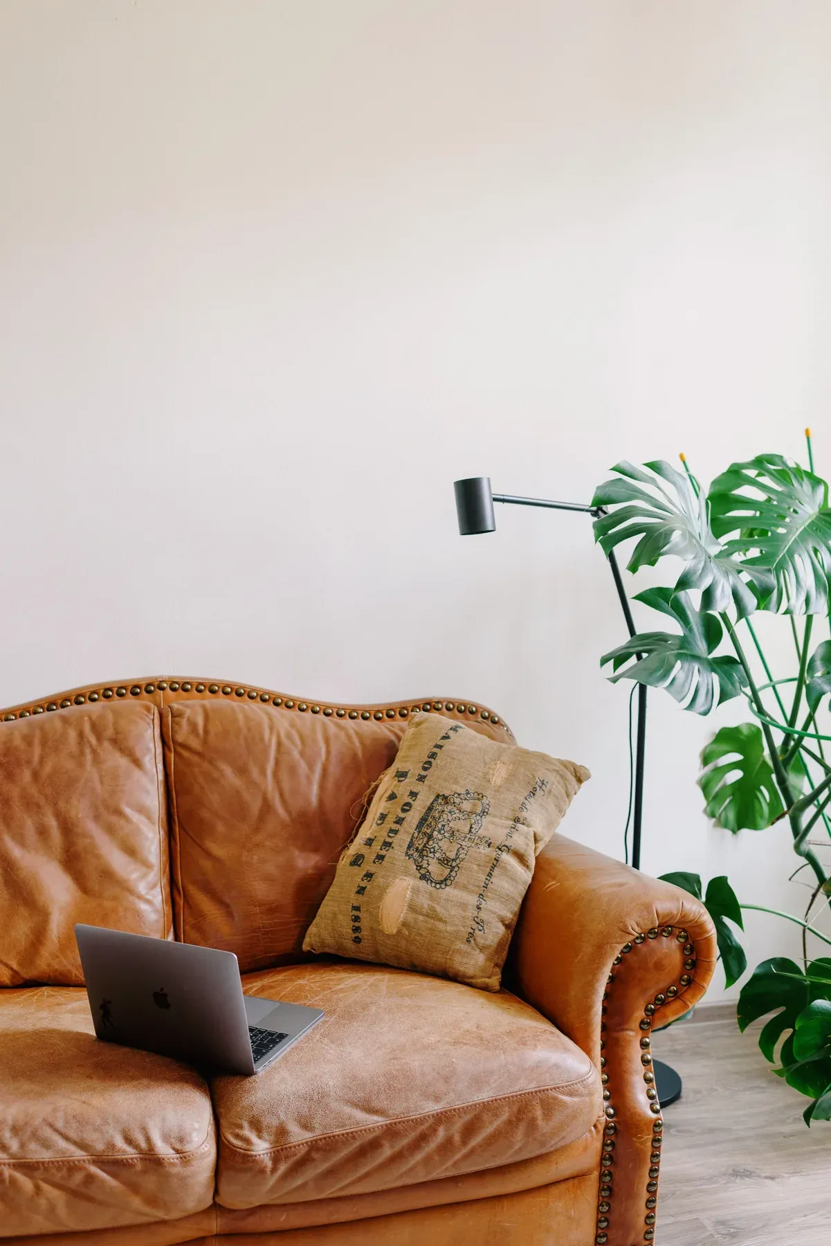 Tan leather sofa in a bright living room — reference image for the AIWAN three-seat leather sofa