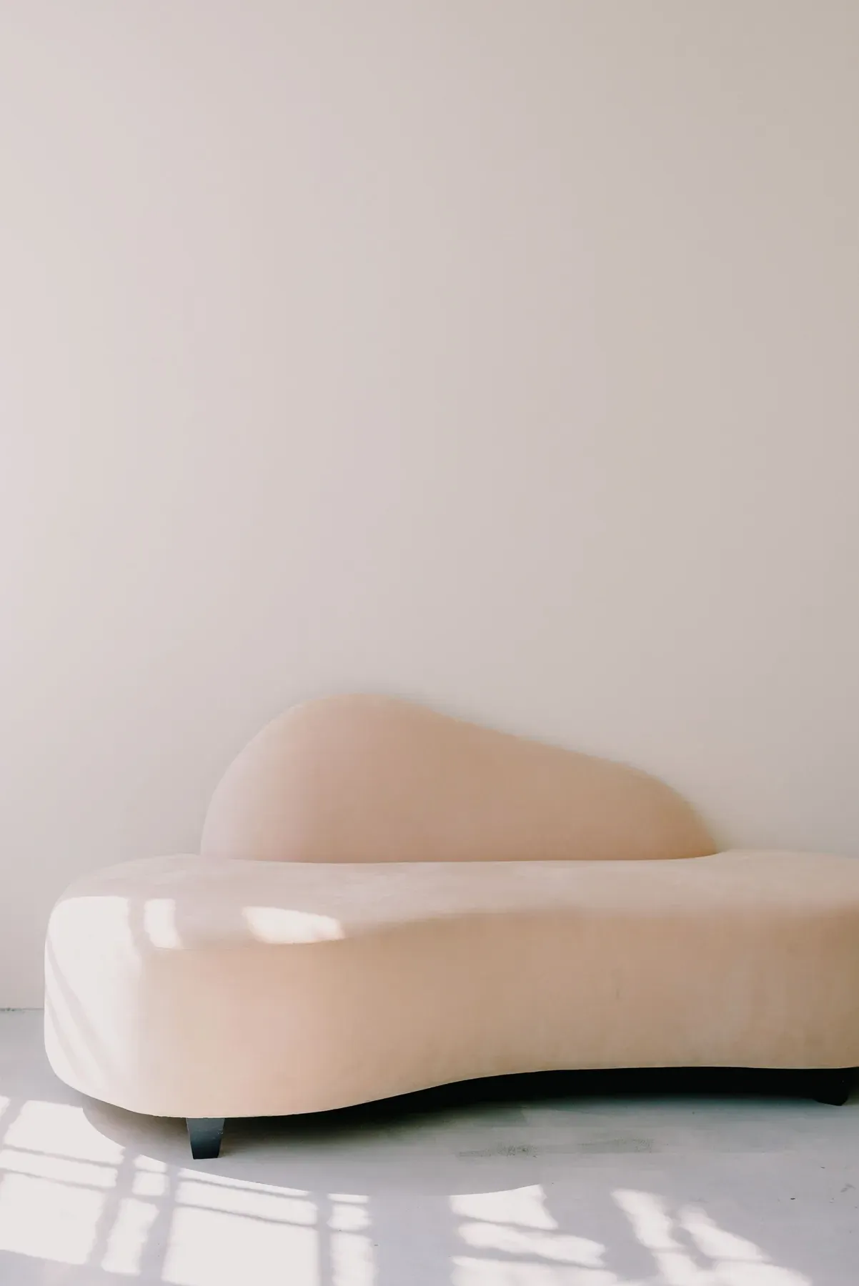 Cream sculpted chaise lounge in a minimal room — reference image for the NASHEMAN sculpted chaise