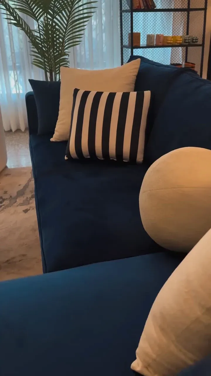 Close view of the NEELAM sofa arm and back cushion in deep blue fabric