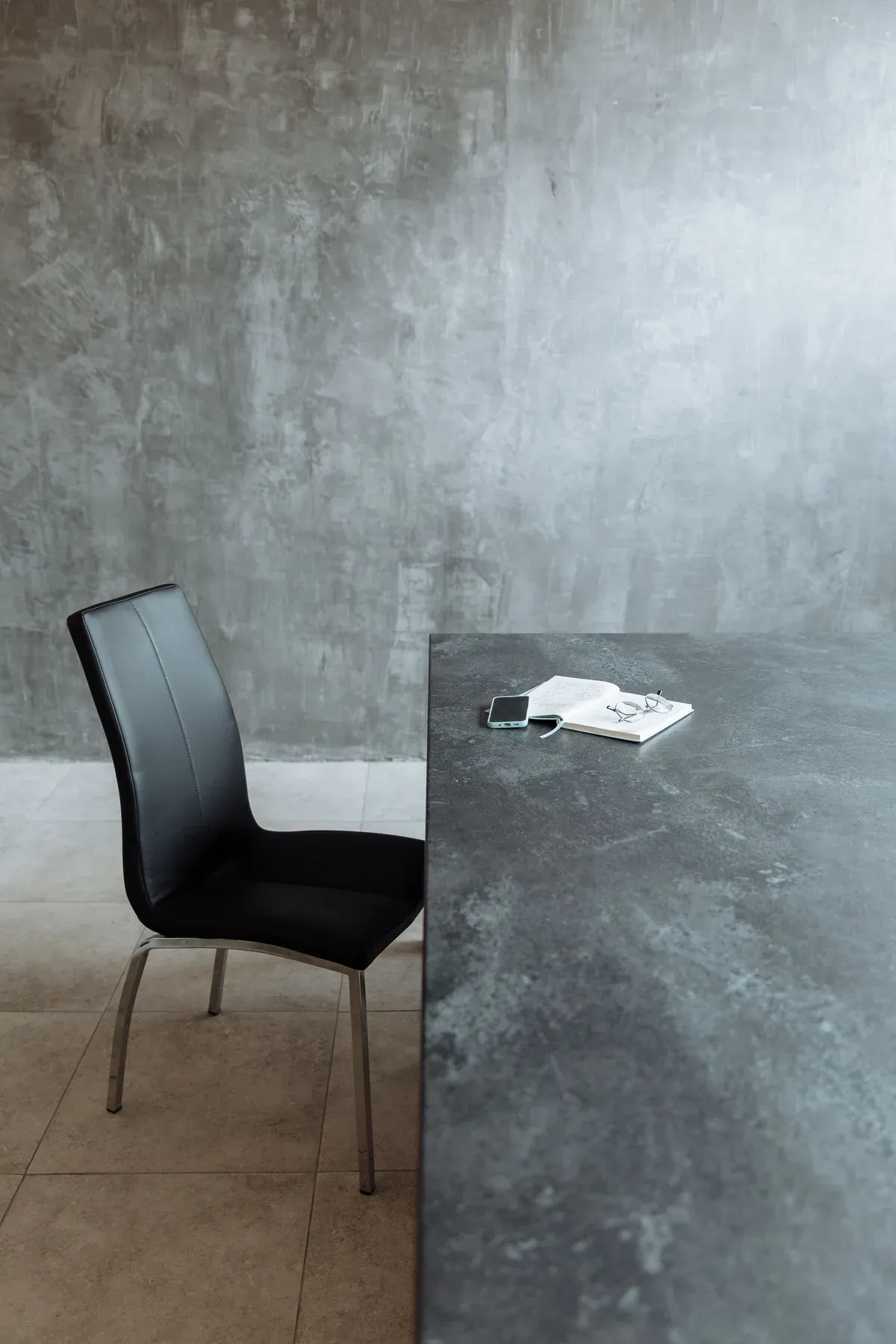 Dark stone desk with a slim black chair — reference image for the FIKR stone-top writing desk