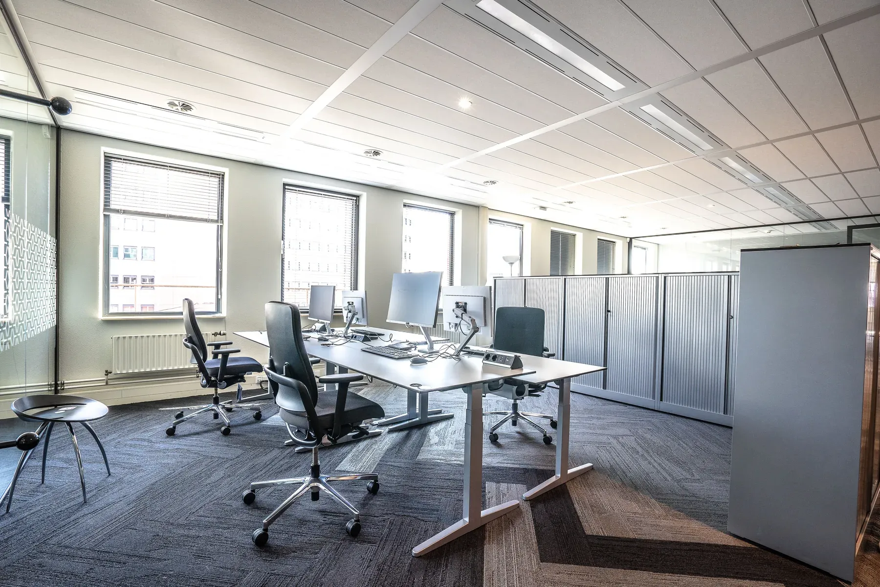 Open office desks with adjustable task chairs — reference image for the MASHQ open-plan desk bank