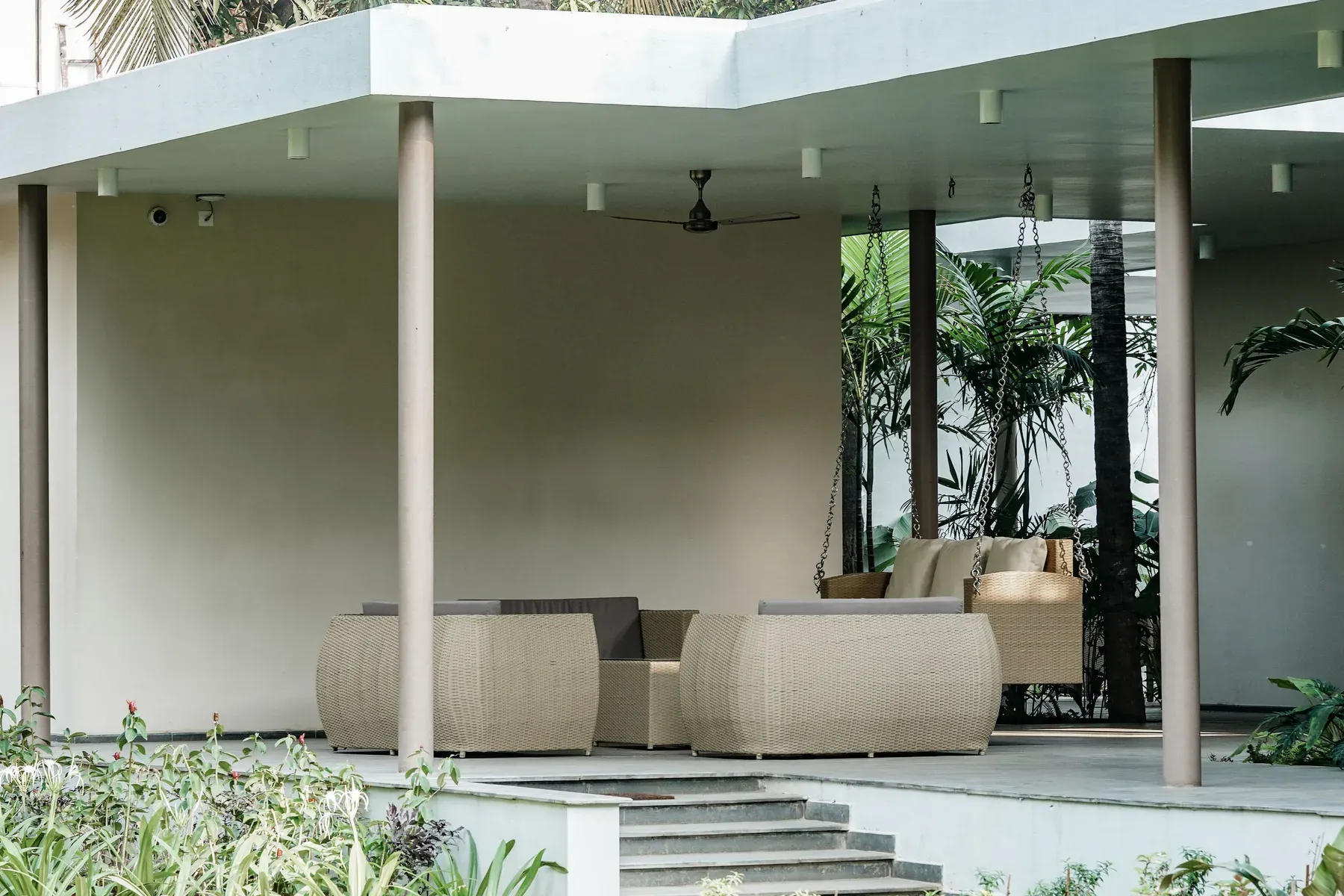 Covered wicker lounge set on a modern patio — reference image for the SAYA covered wicker lounge set