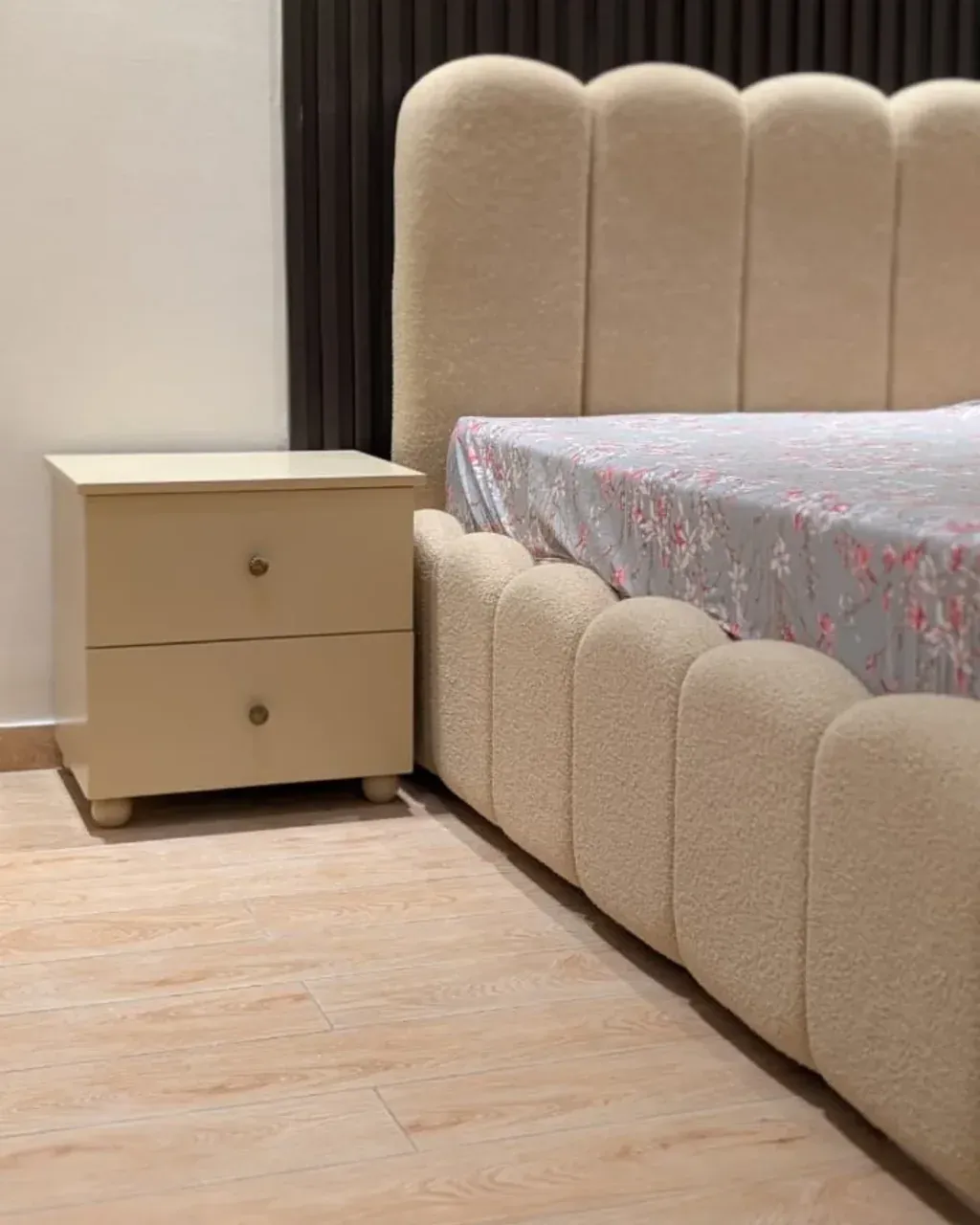 ROSHNI Bedside Table, beside an upholstered bed in a bedroom