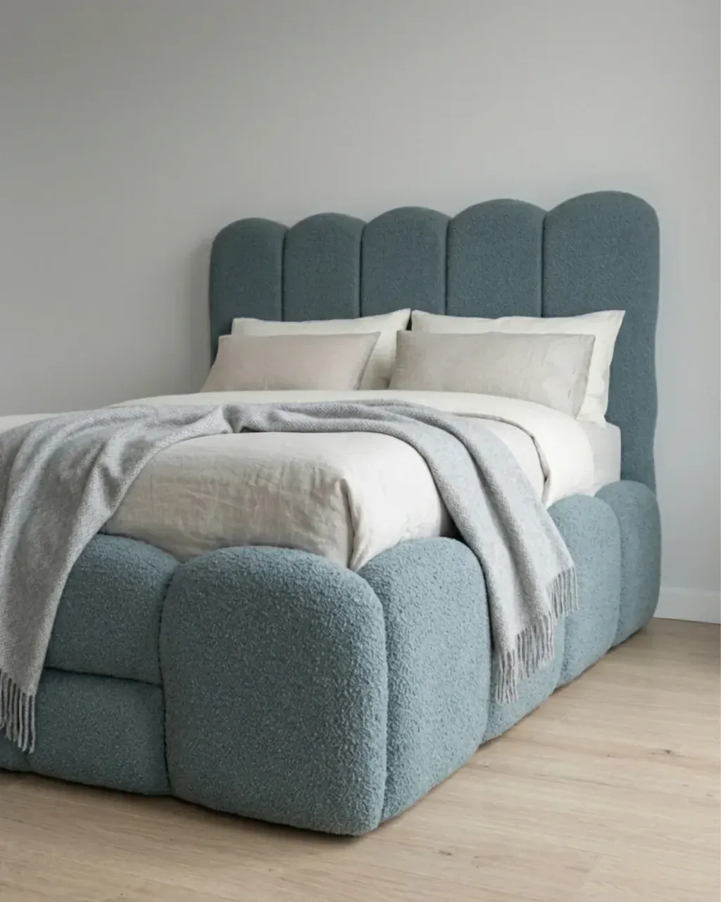 SAVERA Boucle Bed, angled view with a grey throw on the bed